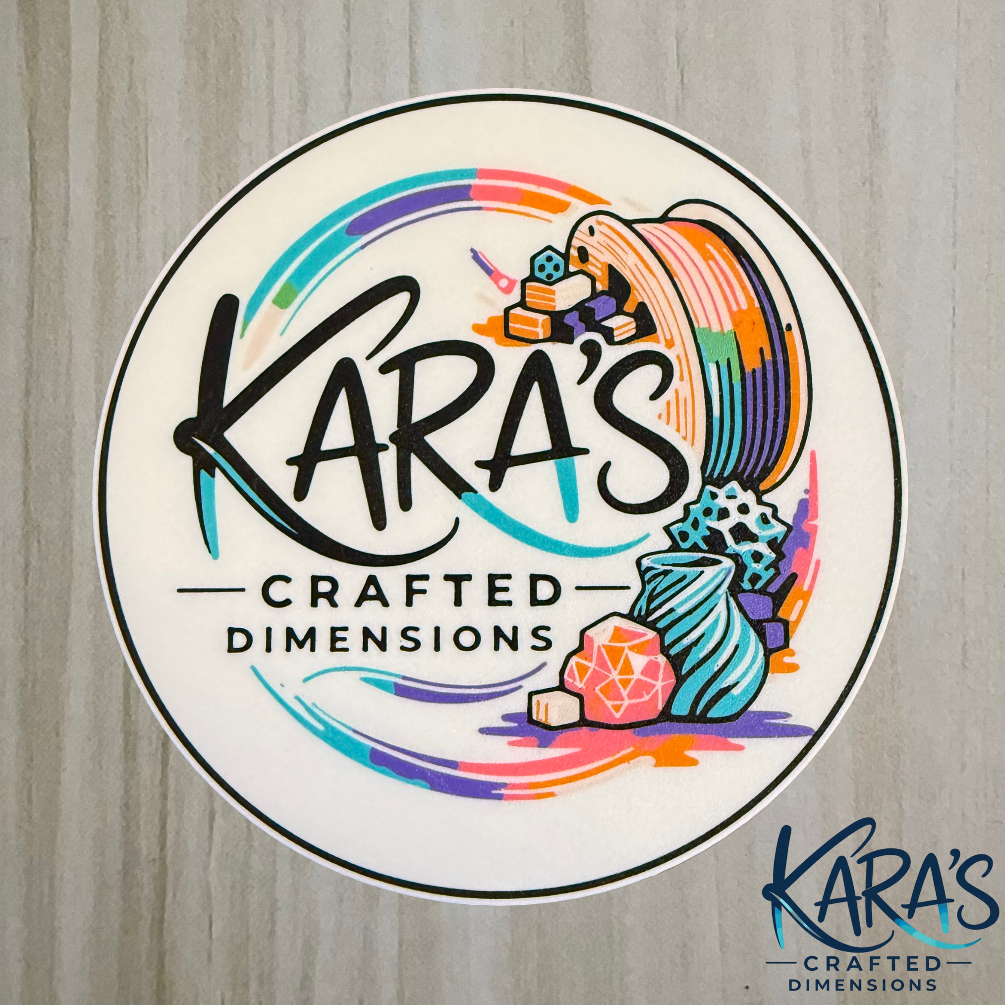 Logo of Kara's Crafted Dimensions with colorful design elements on a wooden background