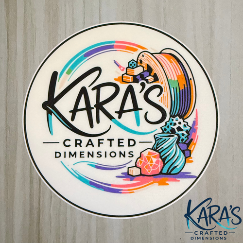 Logo of Kara's Crafted Dimensions with colorful design elements on a wooden background